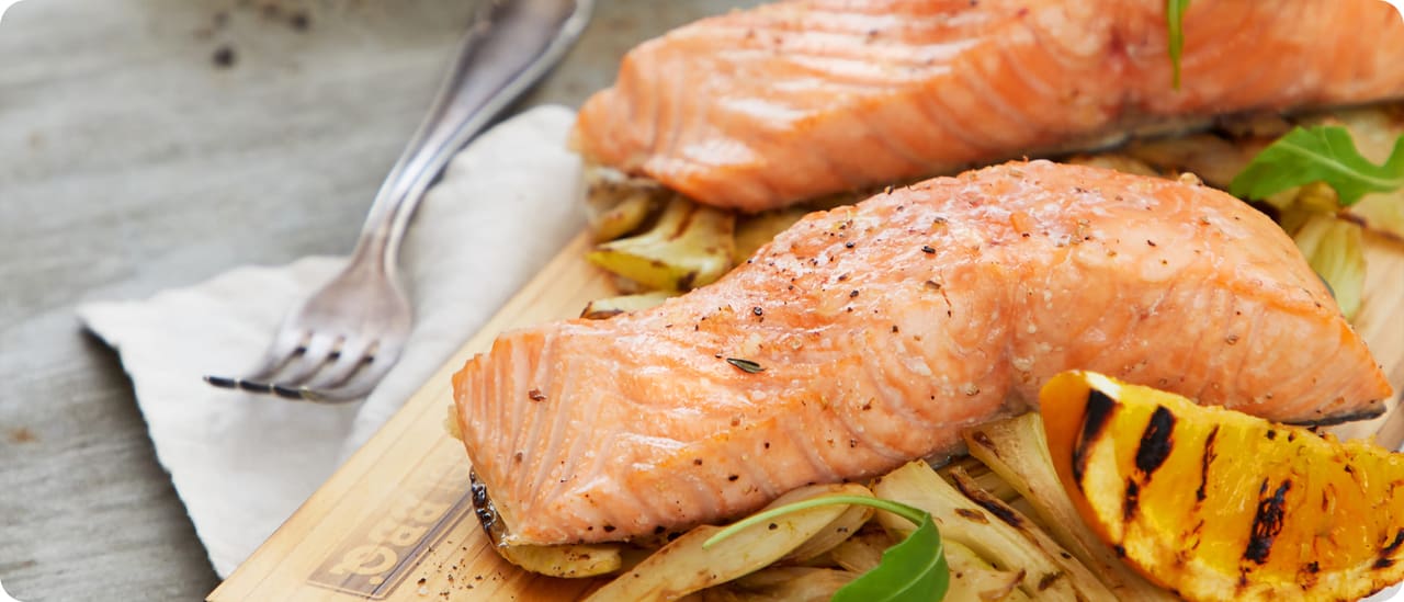 Lachstranche auf Zedernplanke mit Fenchel und Rucola