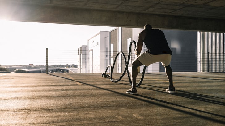 Un homme s’entraîne avec de lourdes cordes