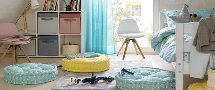 Kinderzimmer mit Kissen und Spielzeuge auf dem Boden.
