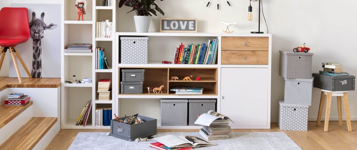 Un système de meubles modulaires avec différents produits comme des livres, des jouets pour enfant et des boîtes de rangement.