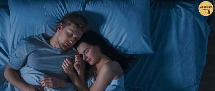 Un homme et une femme dorment dans un lit