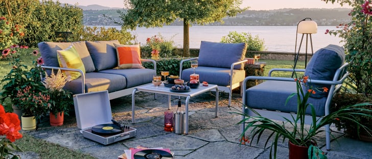 Farbenfrohe Apéro-Szene in einer gemütlichen Garten-Lounge bei Abenddämmerung