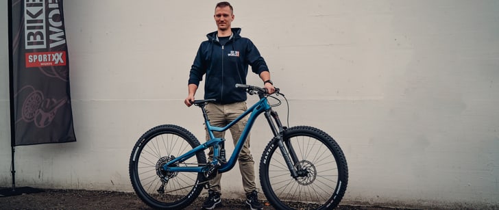 Der Bike World Mitarbeiter Björn steht hinter seinem blauen SCOTT Ransom 930 Mountainbike.