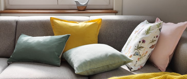 Fünf Kissen auf einem grauen modernen Sofa
