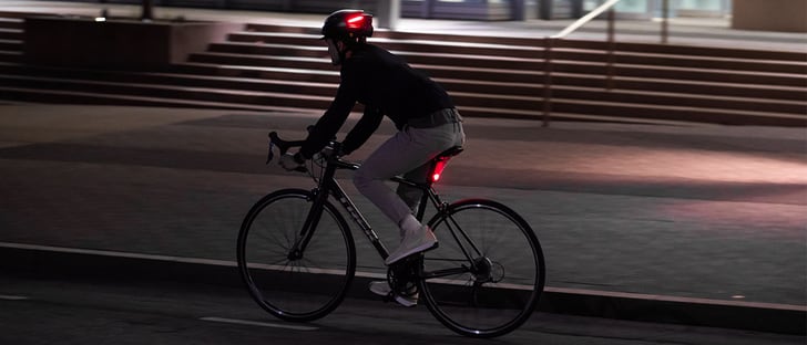 bild eines radfahrers, der einen lumos helm trägt: "radfahrer mit lumos helm, der die straße sicher befährt