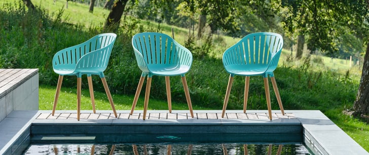 Drei Kunststoff-Stühle neben einem Pool