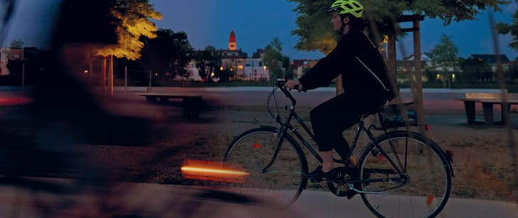 Una donna va in bicicletta al buio