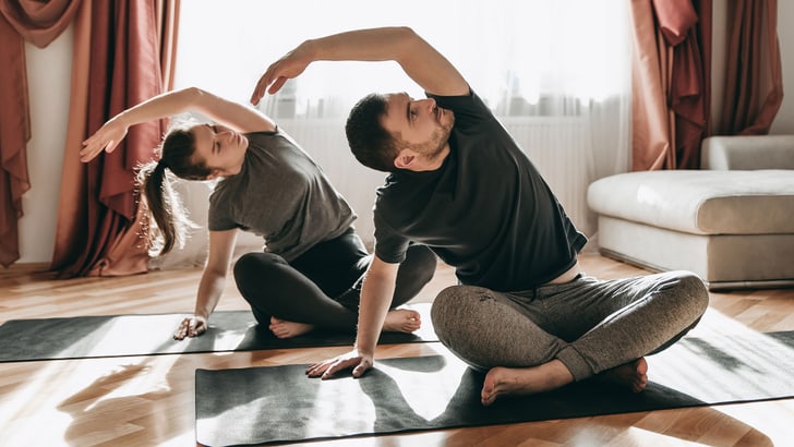 Une femme et un homme s’étirent sur le tapis de yoga