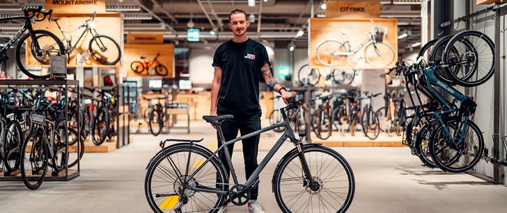 Un vendeur Bike World présente un vélo de ville dans le magasin Bike World.