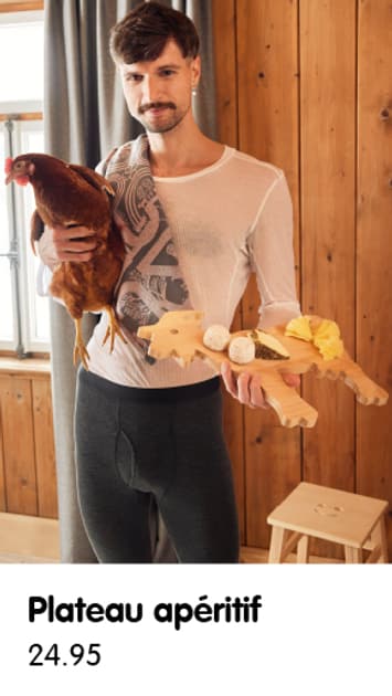 ﻿Une personne tient une poule et un apéro dans une pièce rustique.jpg