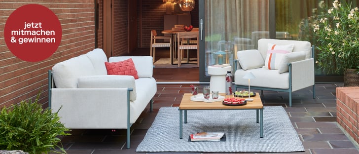 Gemütliche Lounge-Möbel auf einer Terrasse, dekoriert mit Snacks und Getränken. Jetzt mitmachen und gewinnen!