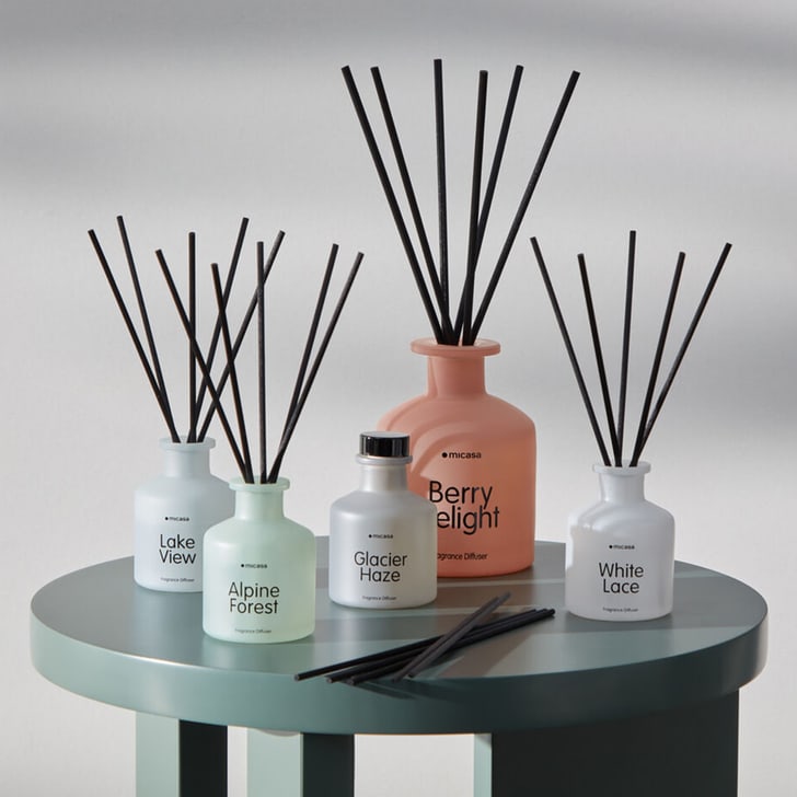 Cinq diffuseurs de parfum avec differentes senteurs sur une table.