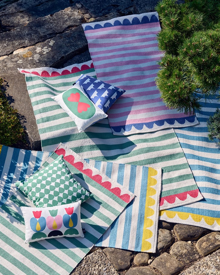 Tapis et coussins colorés sur sol en pierre à l'extérieur.
