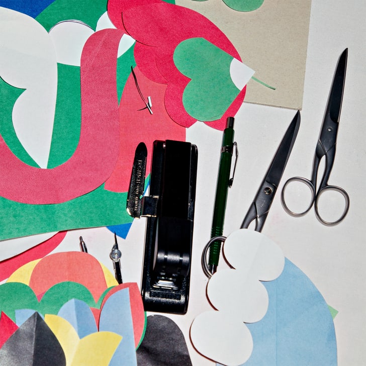 Formes en papier colorées, ciseaux et agrafeuse sur une table.