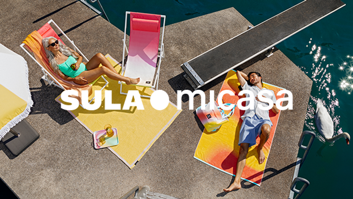 Frau und Mann liegen auf farbigen Sommer-Accessoires auf einem Steg am See