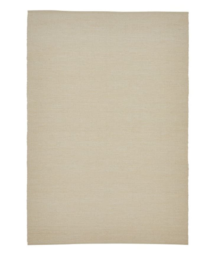 Un tapis rectangulaire beige.