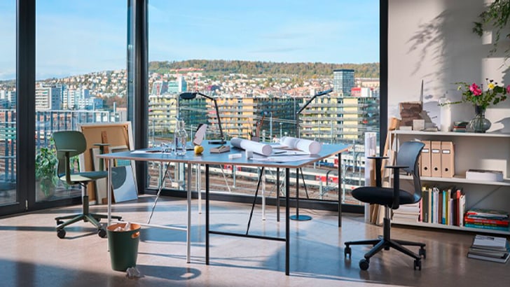 Bureau moderne à domicile avec vue sur la ville par de grandes baies vitrées.