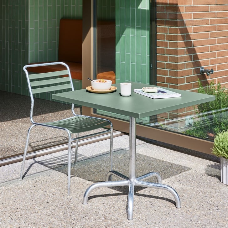 Petite table avec petit-déjeuner et livre sur la terrasse par temps ensoleillé.