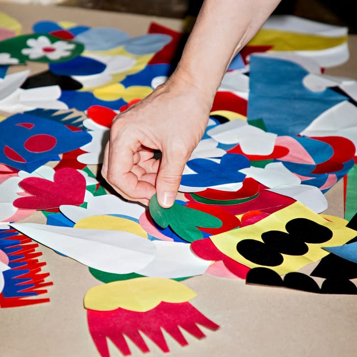 Main trie des formes en papier colorées sur une table.