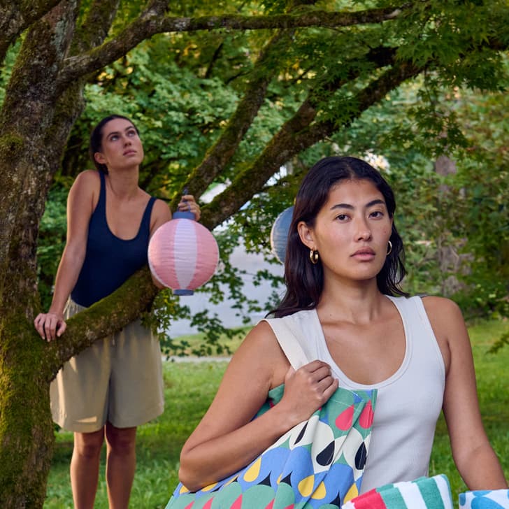 Scène estivale dans le jardin avec des lanternes colorées et une serviette de plage.