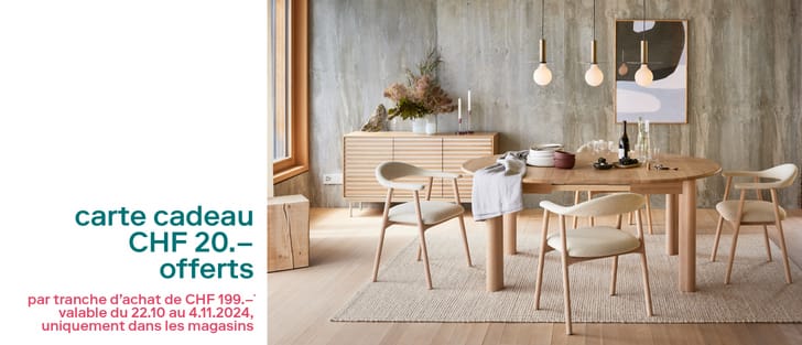 Salle à manger moderne avec mobilier en bois et mur en béton, promotion de carte-cadeau sur le côté gauche.