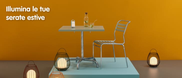 ﻿Combinazione di tavolo e sedia da giardino in uno studio di colore arancione decorato con luci colorate da esterno