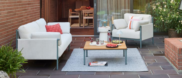 Mobilier de salon moderne sur une terrasse avec des snacks et des boissons pour un moment de détente.