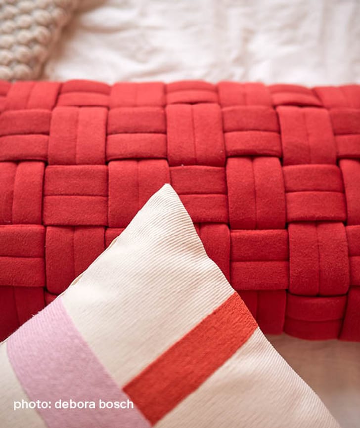 Deux coussins en rouge et crème avec des motifs géométriques.