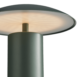 Détail d&apos;une lampe de table moderne avec pied en métal vert et abat-jour éclairé.