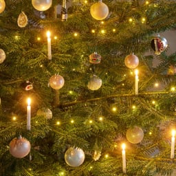 Primo piano di un albero di Natale con luci e palline.