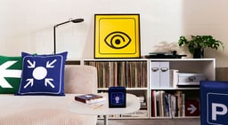Salon avec coussins graphiques et œuvre d&apos;art.