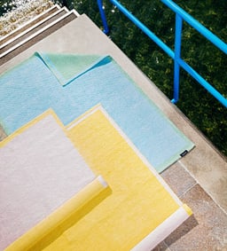 Tapis d&apos;extérieur colorés sur un escalier près de l&apos;eau.