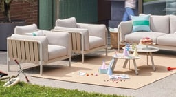 Gemütliche Lounge-Ecke im Freien mit Sofas und Tisch.