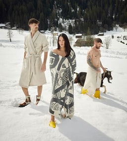 Personnes dans la neige, enveloppées dans des couvertures et des peignoirs.