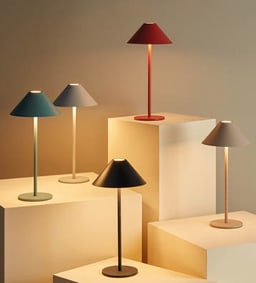 Fünf farbenfrohe Tischlampen auf Podesten.