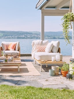 ﻿Scène de jardin avec un salon de jardin au bord du lac, le soleil brille et donne envie de passer une journée de détente dans la verdure.