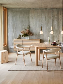 Stilvolles Esszimmer mit modernen Möbeln und hängenden Pendelleuchten.