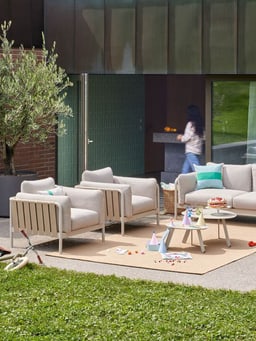 Set di mobili da giardino moderno con decorazioni e una persona sullo sfondo.